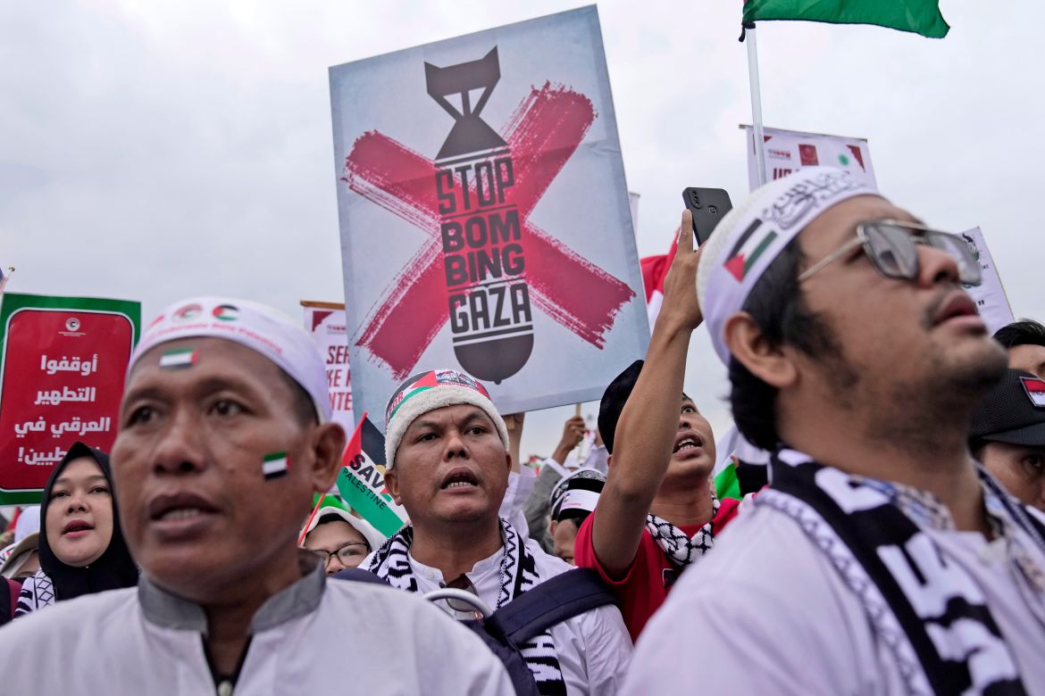 Protesters display posters during a rally in support of the Palestinians in Gaza, at the National Monument in Jakarta