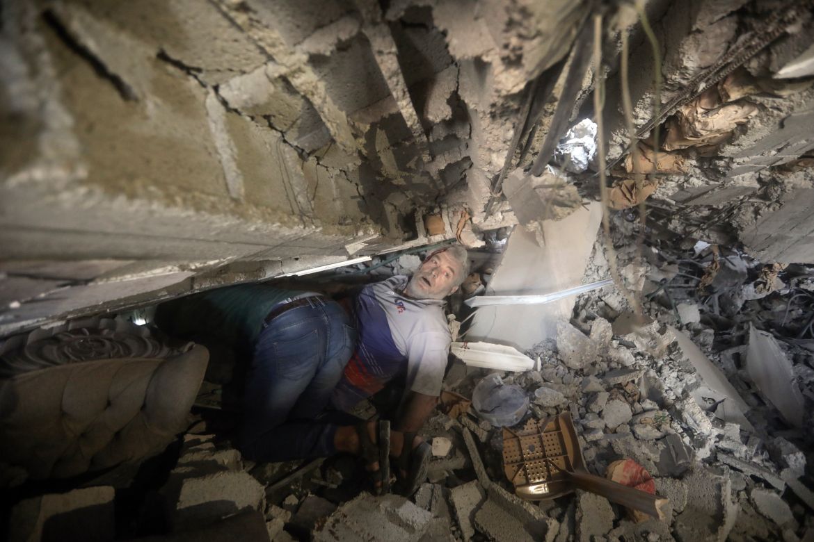 Palestinians try to release a man from under the rubble of a destroyed building following an Israeli airstrike in Khan Younis refugee camp, southern Gaza Strip.