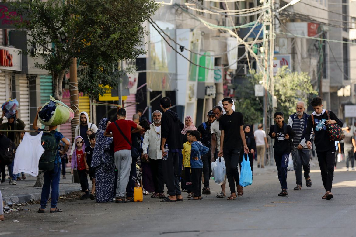 Palestinians walk in the al-Rimal neighbourhood, central Gaza City while fleeing to the southern Gaza Strip.