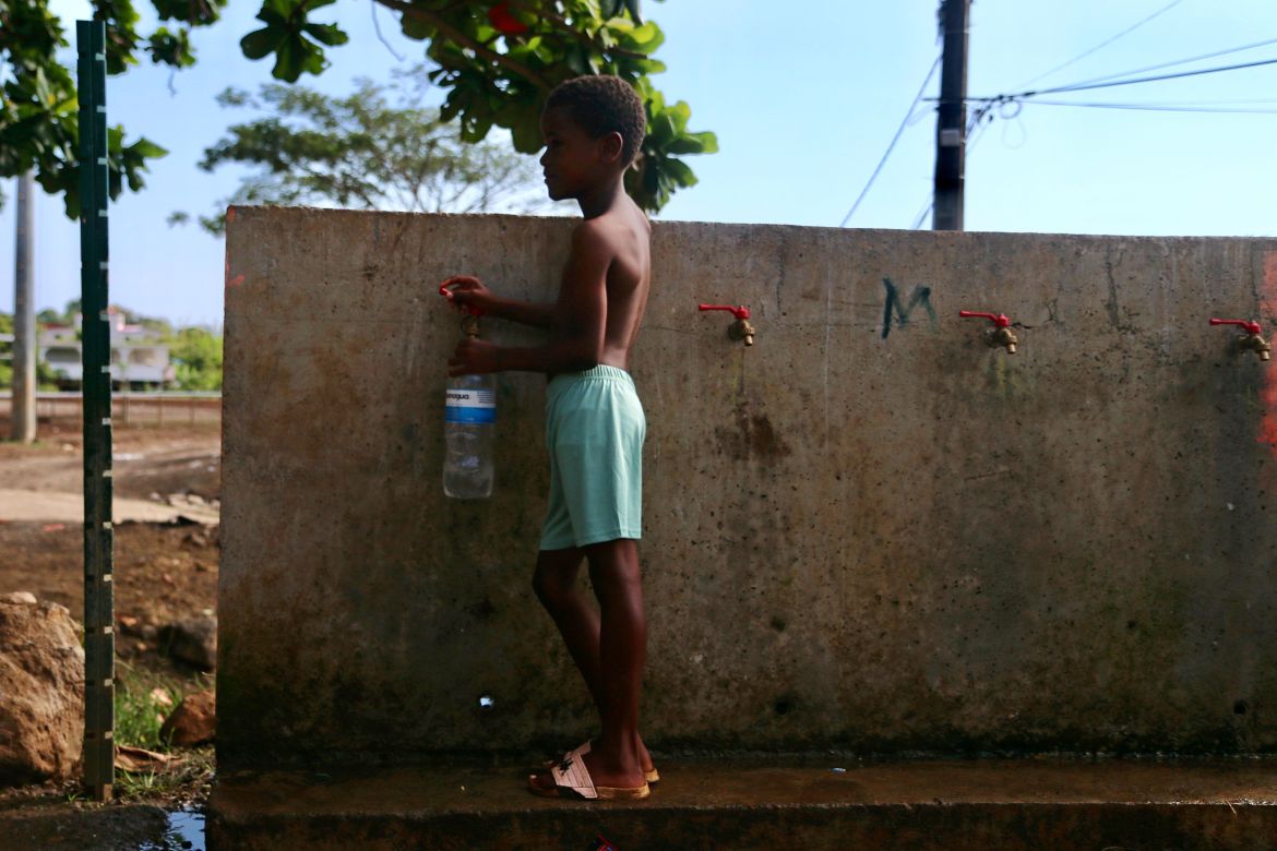 A boy fills up a bottle at the water fountain in M'tsamoudou, near Bandrele on the French Indian Ocean territory of Mayotte.