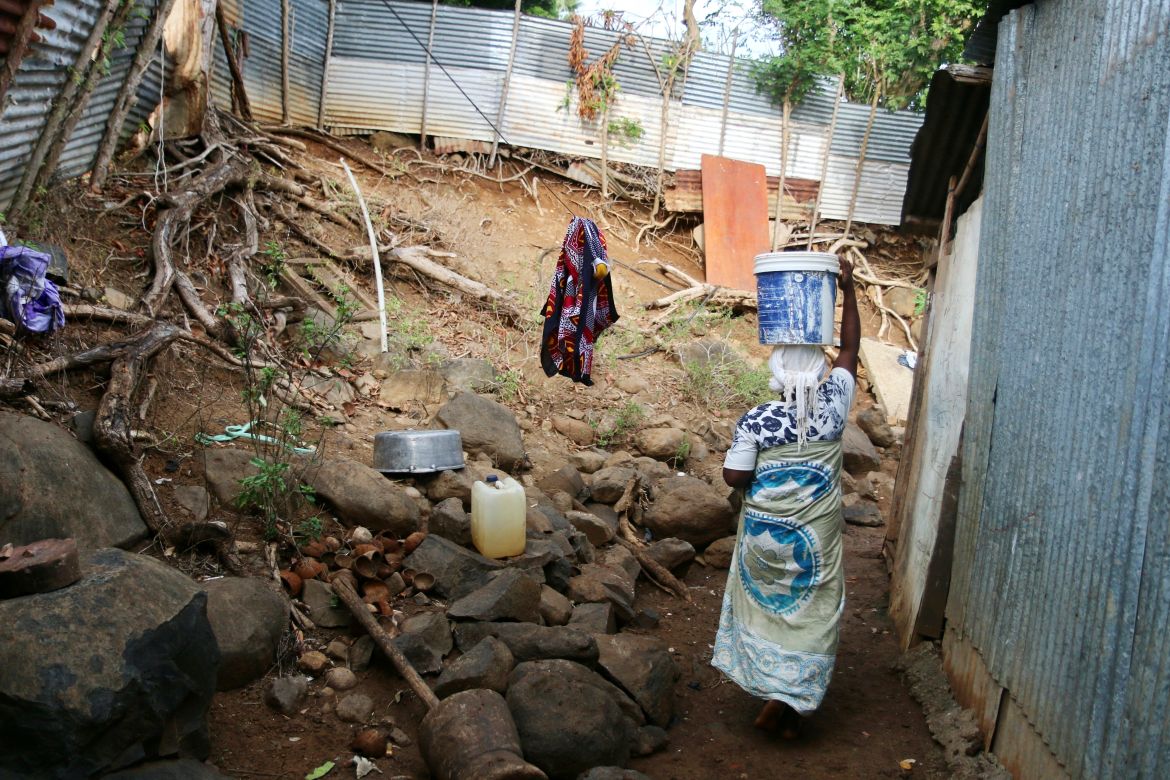 A woman carries a bucket of water on her head in the district of M'tsamoudou, near Bandrele, on the French Indian Ocean territory of Mayotte.