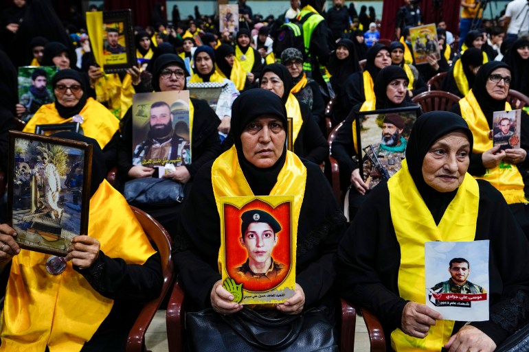 Sostenitori di Hezbollah tengono in mano le foto dei loro parenti morti combattendo con Hezbollah mentre ascoltano un discorso del leader di Hezbollah Sayyed Hassan Nasrallah tramite un collegamento video, durante una cerimonia che celebra il "Giorno dei martiri di Hezbollah", nel sobborgo meridionale di Dahiyeh, a Beirut, in Libano. Sabato 11 novembre 2023 [Hassan Ammar/AP Photo]