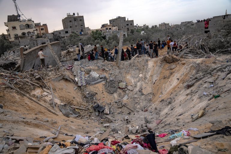 Belongings can be seen strewn around a crater in Khan Younis on Sunday