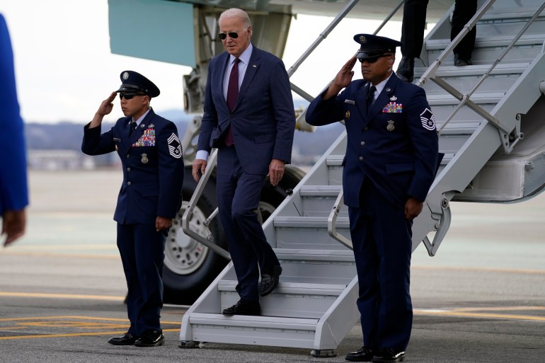 El presidente Joe Biden llega al aeropuerto de San Francisco, se para cerca de los escalones del avión y dos guardias a cada lado saludan.
