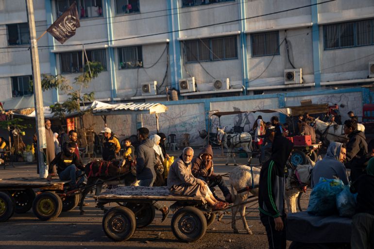 Palestinians ride donkey carts during the ongoing Israeli bombardment of the Gaza Strip in Khan Younis on Friday
