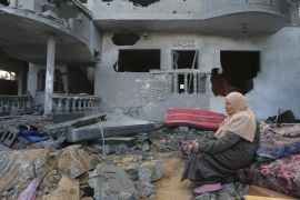 Woman sits in destroyed building Gaza