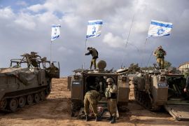 Israeli soldiers work on armored military vehicles near the Gaza Strip on Monday, Nov. 20, 2023 [AP Photo/Ohad Zwigenberg]