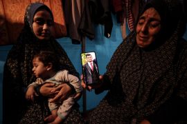 Zeenat al-Samouni shows a photo of her son Abdullah, 24, who was taken by Israeli soldiers at a checkpoint on the so-called &#039;safe corridor&#039; in Gaza [Abdelhakim Abu Riash/Al Jazeera]