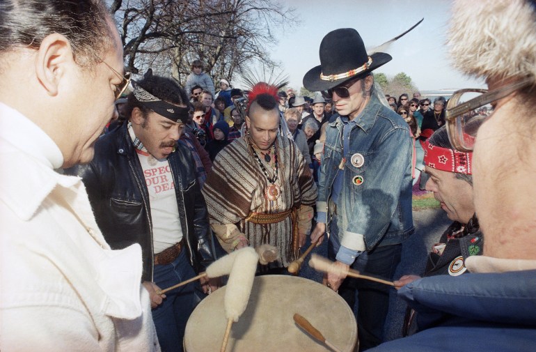 Men in an archival photo stand in a drum circle on Cole's Hill, Massachusetts.