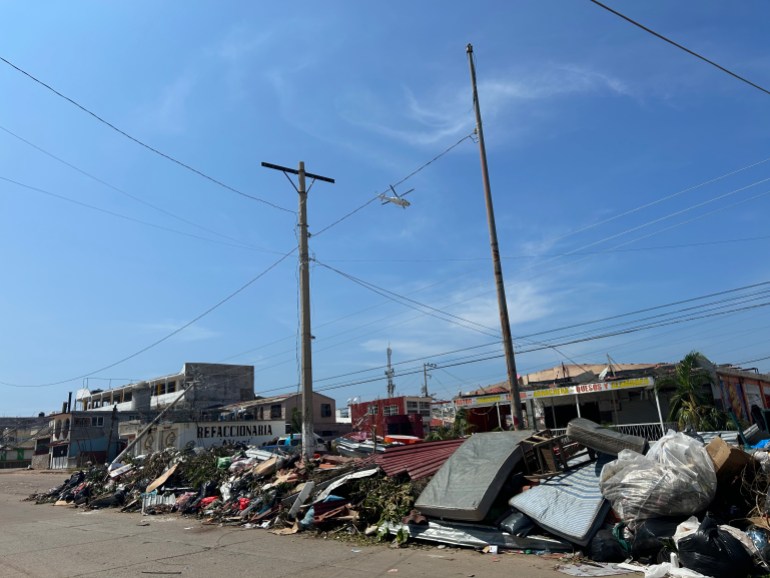 Debris sits piled up under power lines in Acapulco, Mexico, after Hurricane Otis.