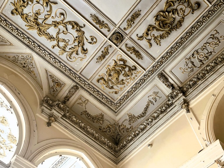 A moulded, gilt ceiling in greys and gold
