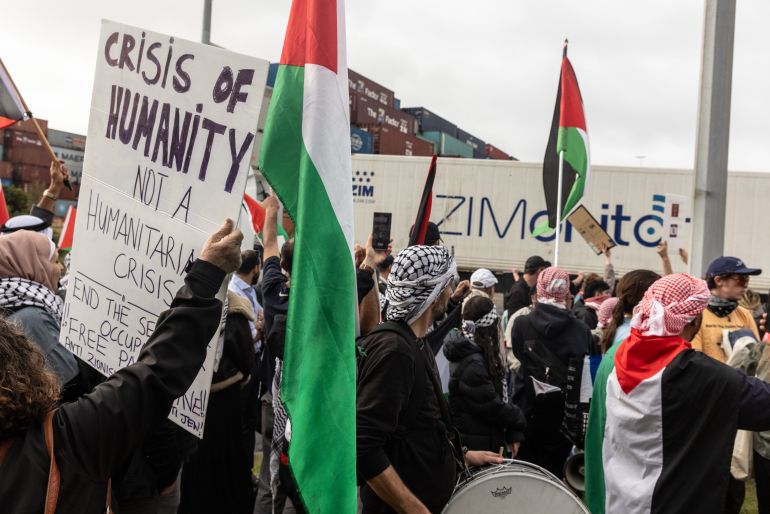 a crowd can be seen in front of a shipping container that says ZIM