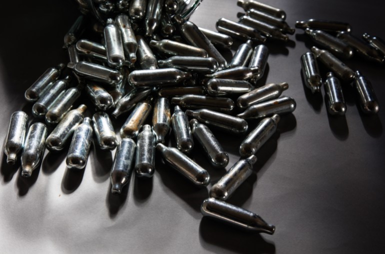 Thousands of empty canisters of nitrous oxide
