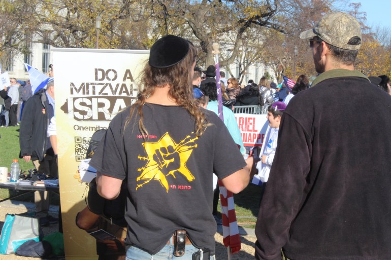 Pro-Israel protester with a shirt featuring the Kahanist movement symbol of a clenched fist against a yellow star
