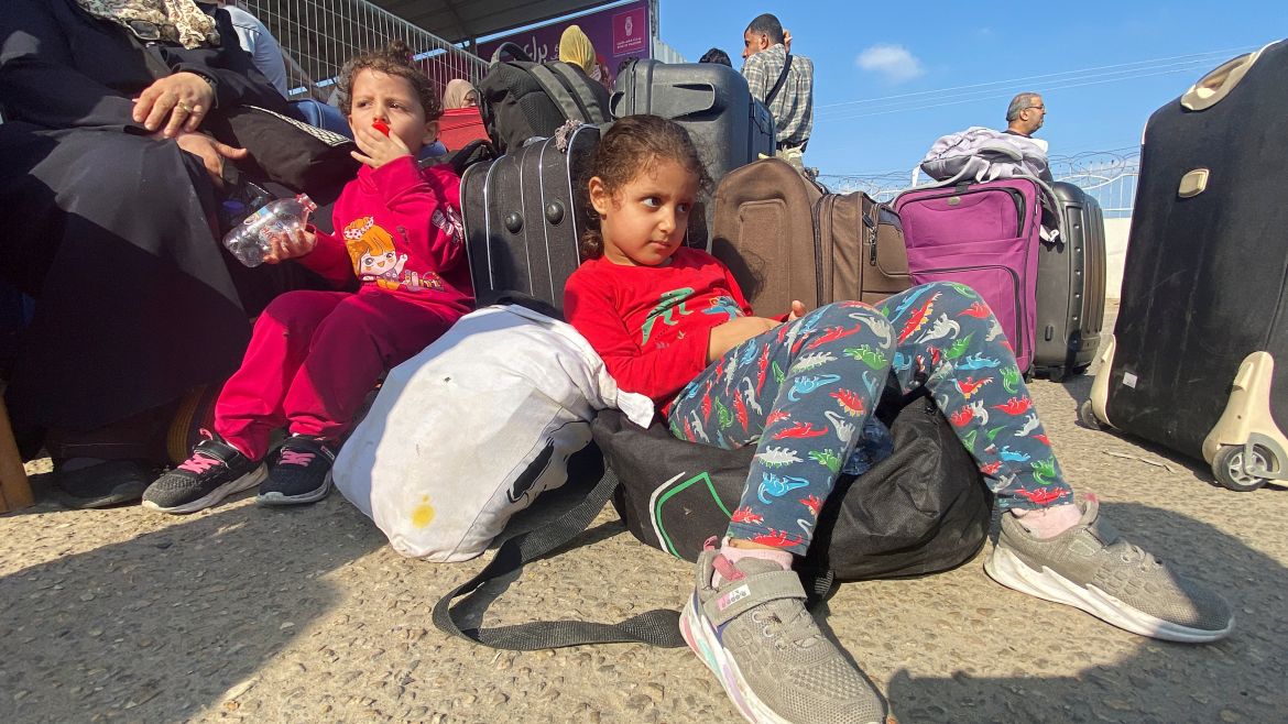 Palestinian children with dual citizenship wait outside the Rafah border