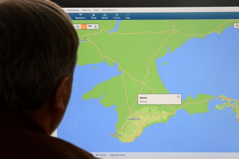 A man looks in Moscow on March 21, 2014, at a computer screen displaying a map of Crimean peninsula with a pop-up window reading: "Crimea, Russia." at the site of a Russian Internet company Mail.Ru.