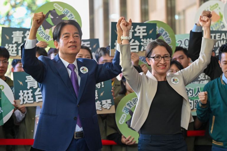 Taiwan presidential candidate Lai Ching-te (L) and his running mate Hsiao Bi-khim (R), from the ruling Democratic Progressive Party (DPP), gesture in front of supporters after they registered running for the 2024 presidential elections in Taipei on November 21, 2023. (Photo by Sam Yeh / AFP)