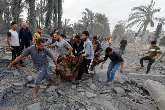 Palestinians carry a casualty from an Israeli airstrike