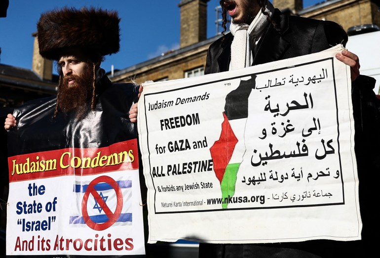 Członkowie ortodoksyjnej społeczności żydowskiej niosą transparenty podczas udziału w „Narodowym Marszu dla Palestyny” w centrum Londynu. [HENRY NICHOLLS / AFP]