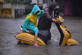 Residents of Chennai waded through waist-deep murky floodwaters [Idrees Mohammed/EPA]