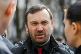 Russian former parliamentarian Ilya Ponomarev speaks with acquaintances after a burial service