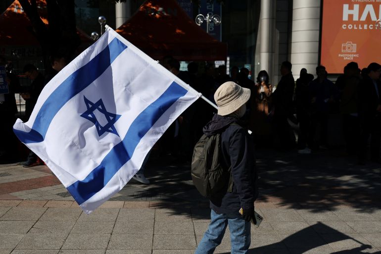 A South Korean woman holds an Israeli flag