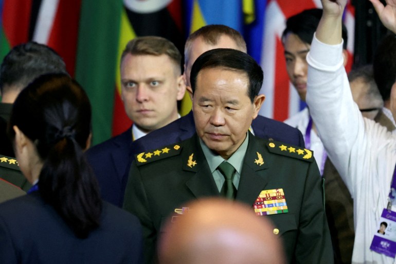 Liu Zhenli of the Central Military Commission arrives at a forum in Beijing. He is wearing his uniform and surrounded by other people.