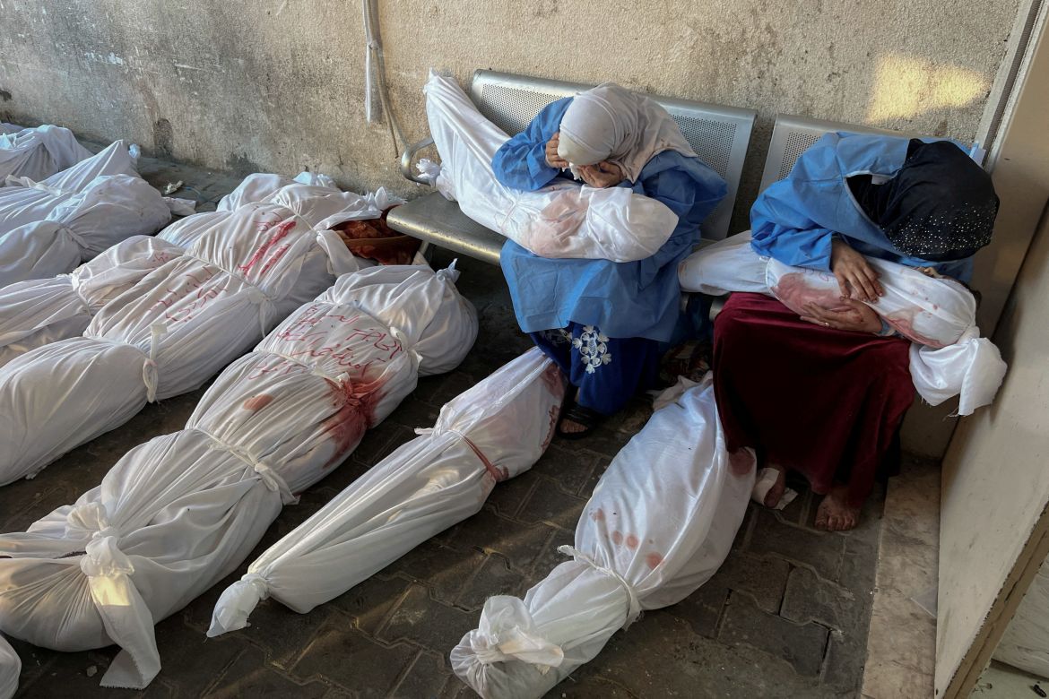 Palestinian women mourn as they hold the bodies of children killed in Israeli strikes, amid the ongoing conflict between Israel and Hamas, at the Indonesian hospital, in the northern Gaza Strip, November 18