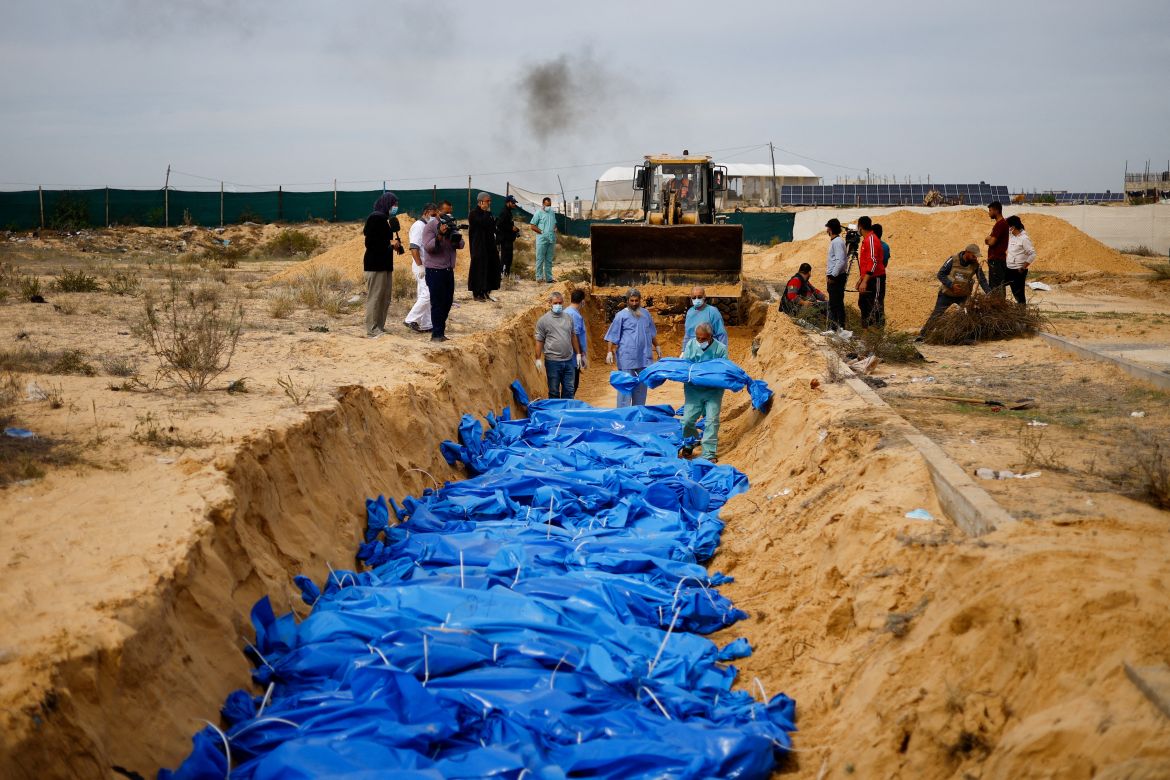 The bodies of Palestinians killed in Israeli strikes and fire are buried in a mass grave, after they were transported from Al Shifa hospital in Gaza City for burial, in Khan Younis in the southern Gaza Strip.