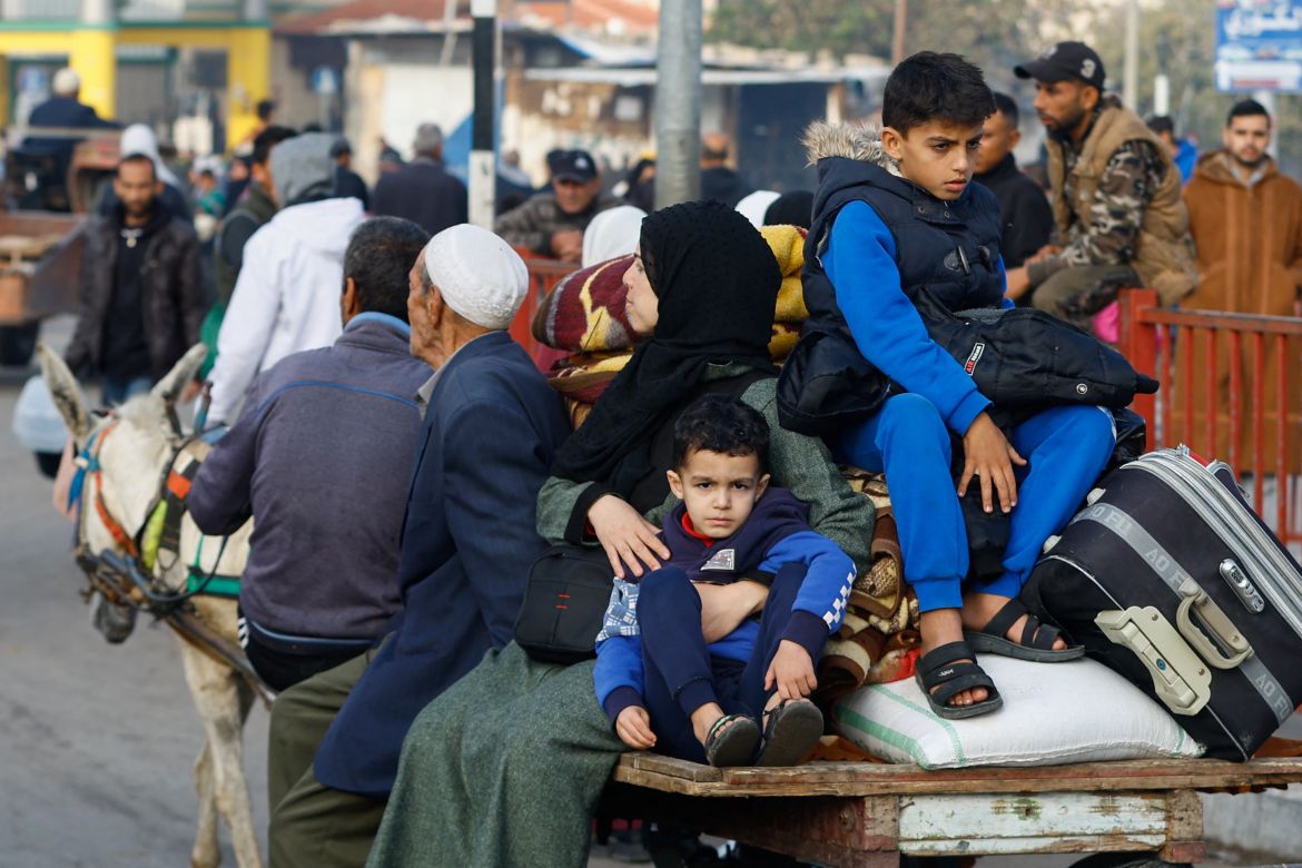 Palestinians boys sit on a trailer, as people flee their houses due to Israeli strikes