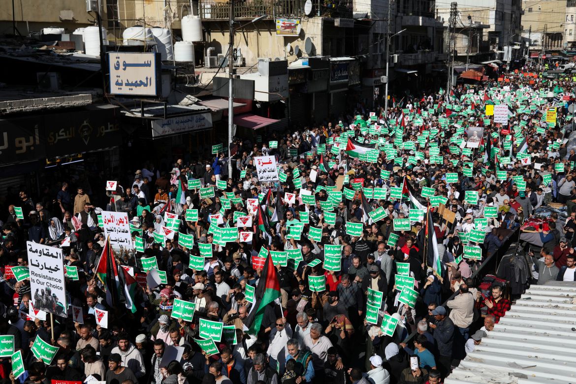 People hold placards during a protest in support of Palestinians in Gaza, in Amman, Jordan December 1