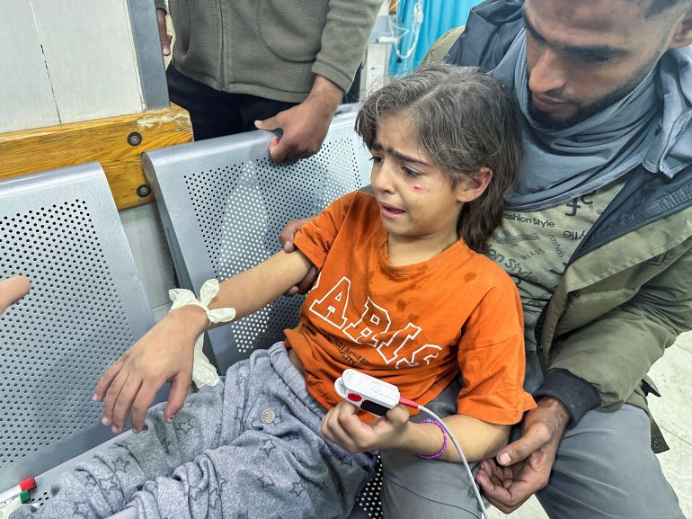A Palestinian girl wounded in an Israeli strike on a house receives medical attention