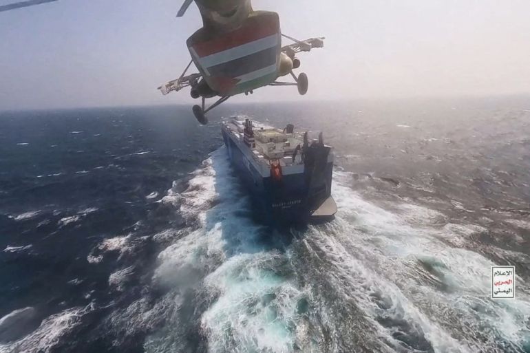 Houthi military helicopter flies over the Galaxy Leader cargo ship in the Red Sea
