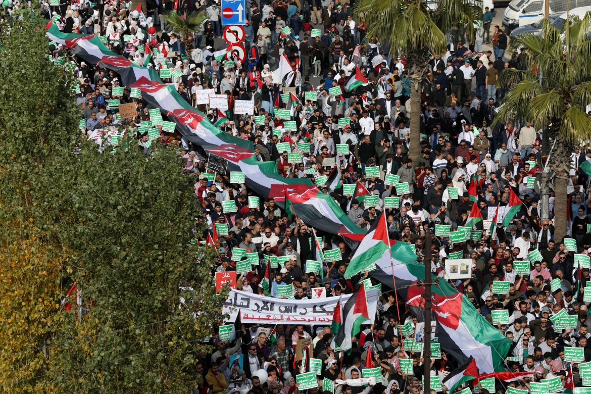 People hold placards and Palestinian flags during a protest in support of Palestinians in Gaza, amid the ongoing conflict between Israel and the Palestinian Islamist group Hamas, in Amman, Jordan