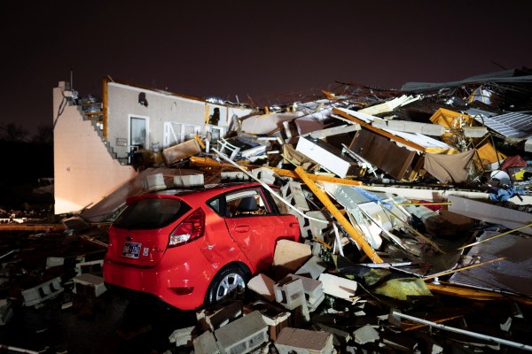 Възстановяващи и спасителни работници оглеждат опустошенията след като мощни торнада