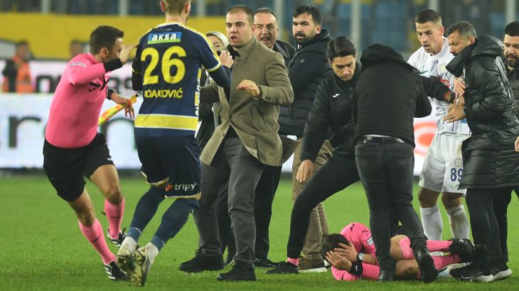 Referee Halil Umut Meler lies on the ground after being hit by Ankaragucu president Faruk Koca