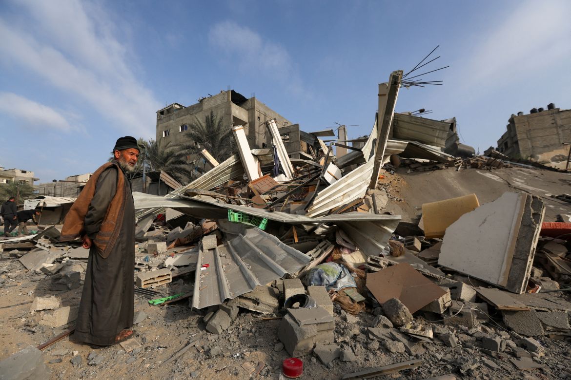 A Palestinian man inspects the damage at the site of Israeli strikes on houses, amid the ongoing conflict between Israel and the Palestinian Islamist group Hamas, in Khan Younis