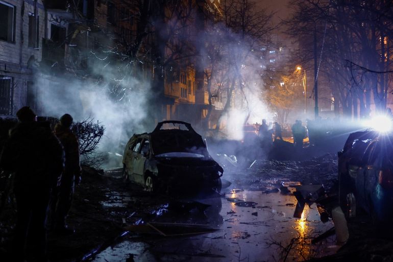 Smoke rising and burned out cars after a Russian missile attack on Kyiv