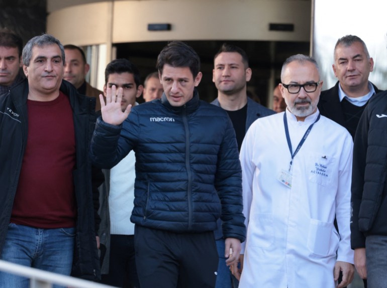 Turkish referee Halil Umut Meler, accompanied by head doctor Mehmet Yorubulut, greets media members as he leaves from a hospital in Ankara, Turkey December 13, 2023. REUTERS/Cagla Gurdogan