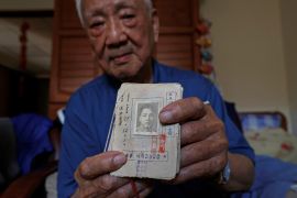 Sun Kuo-hsi, 110, poses with his Kuomintang party membership card, which states he joined the party in 1940, in his room at the Taoyuan Veterans home in Taoyuan, Taiwan.