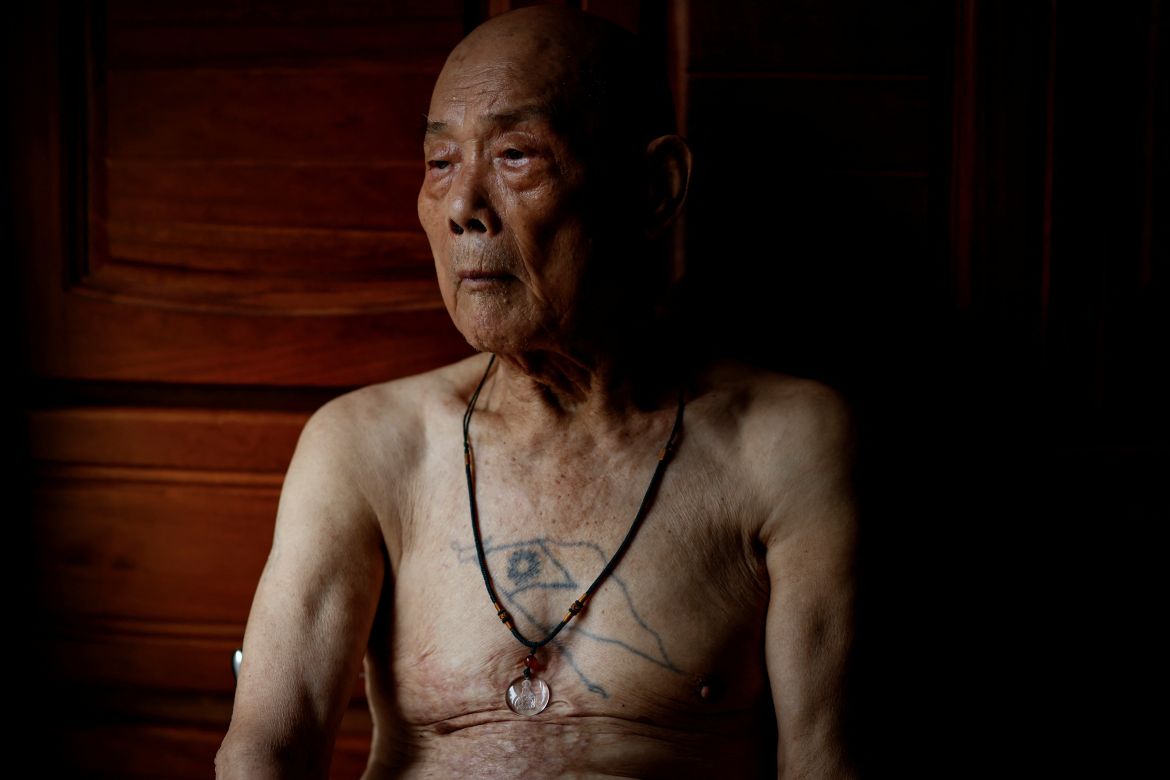Wang Chih-chuan, 93, poses for a photo, with a Taiwanese flag tattoo on his chest, in his room at Taoyuan Veterans Home in Taoyuan, Taiwan.
