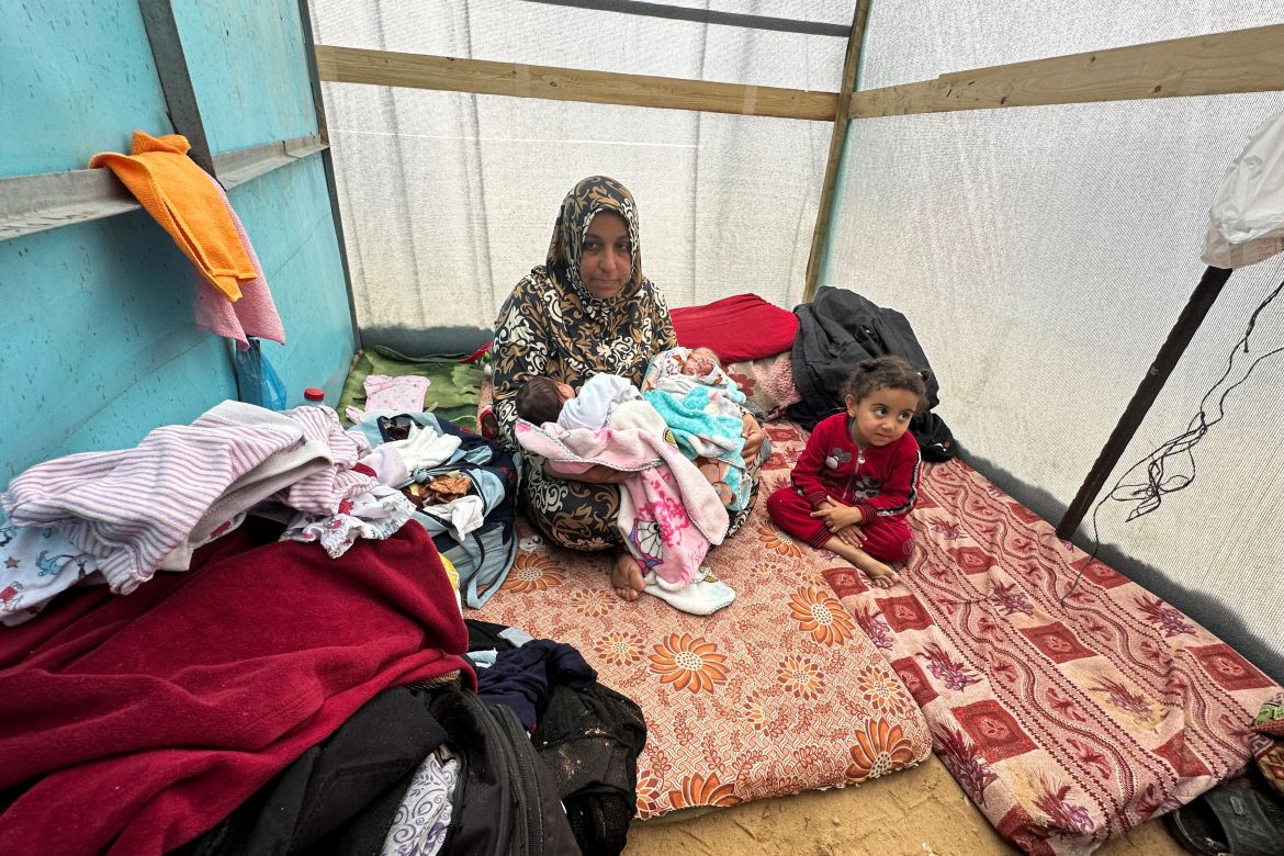 The grandmother of Salma and Alma Al-Jadba, twin Palestinian baby girls who were war born during the conflict between Israel and Hamas, holds them in a tent where they shelter with their displaced family who fled their house due to Israeli strikes, in Rafah.