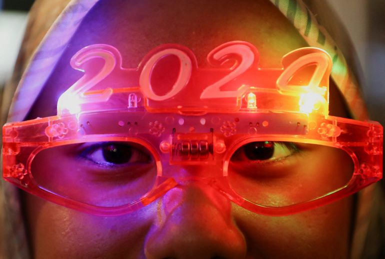A woman wearing 2024 glasses bathed in pink light