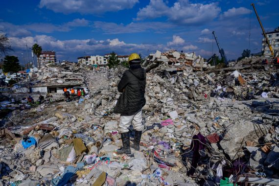 A man stands on the rubble of collapsed buildings in Hatay on February 10, 2023, after a 7.8-magnitude earthquake struck the country's southeast.