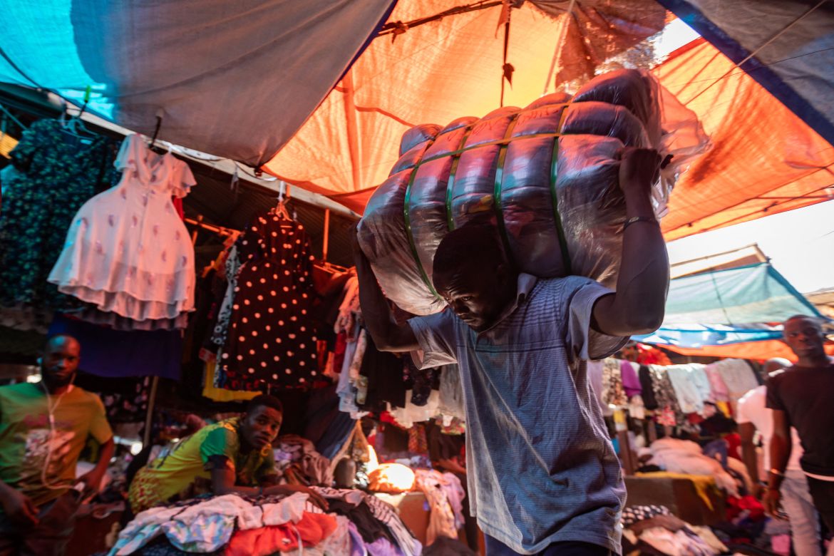 A man carries a load of second-hand clothes at a market in Kampala.