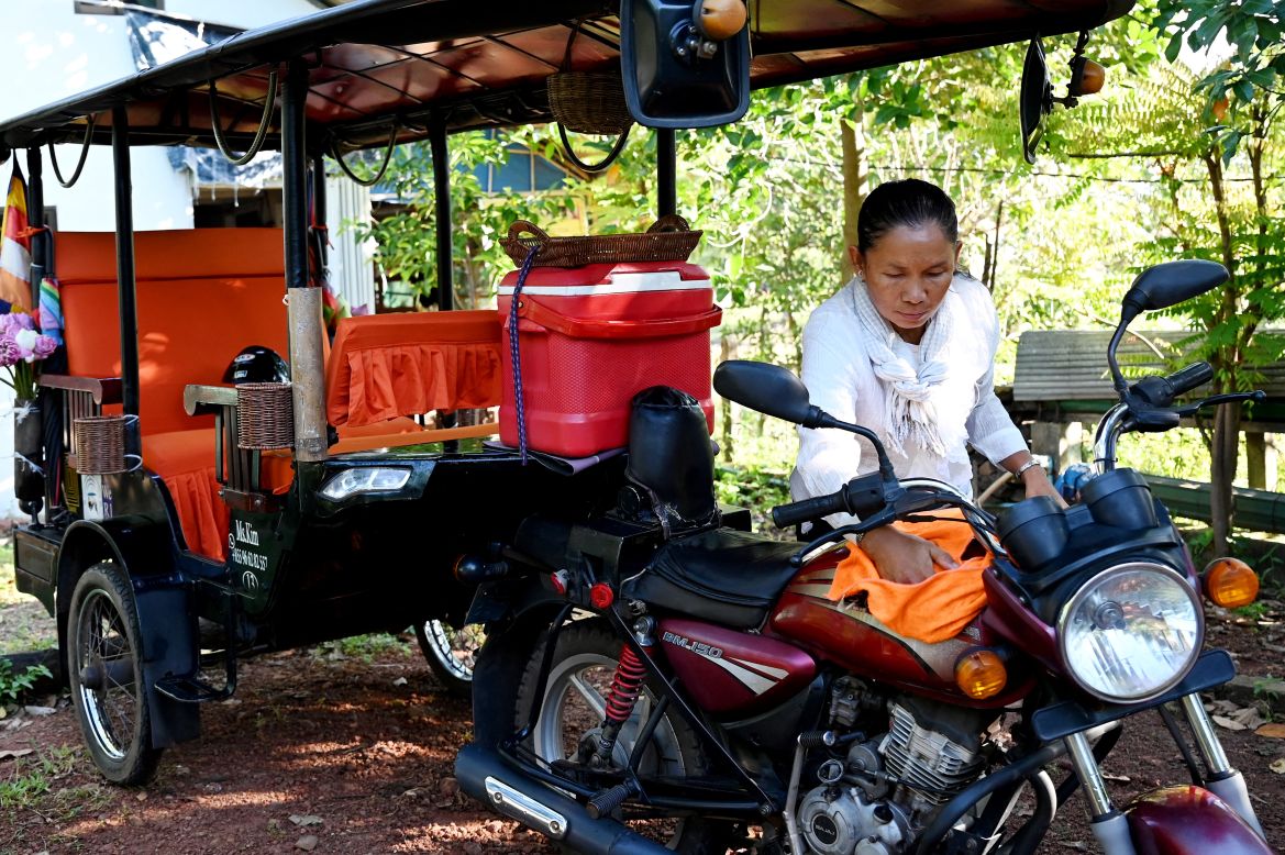 This photo taken on November 18, 2023 shows female Tuk Tuk driver Kim Sokleang cleaning her Tuk Tuk at her house in Siem Reap province.