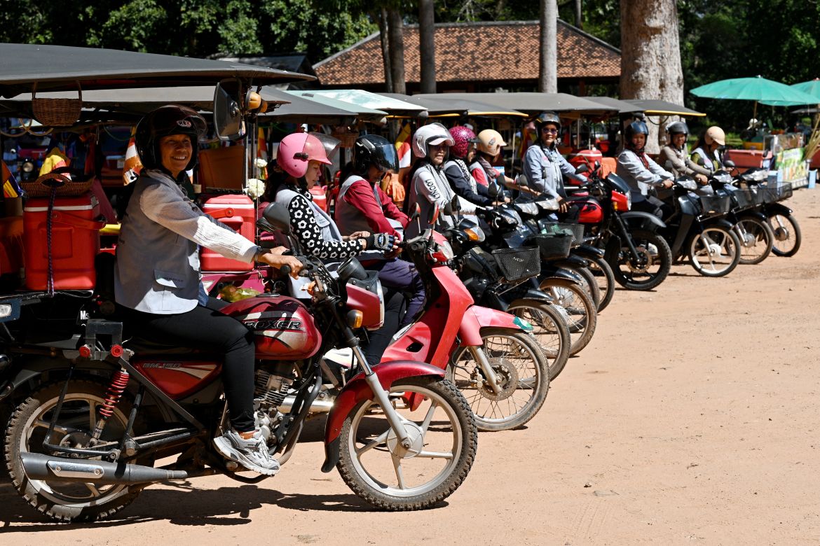 This photo taken on November 17, 2023 shows female Tuk Tuk drivers waiting for their passengers near the terrace of the elephants at the Angkor complex in Siem Reap province.