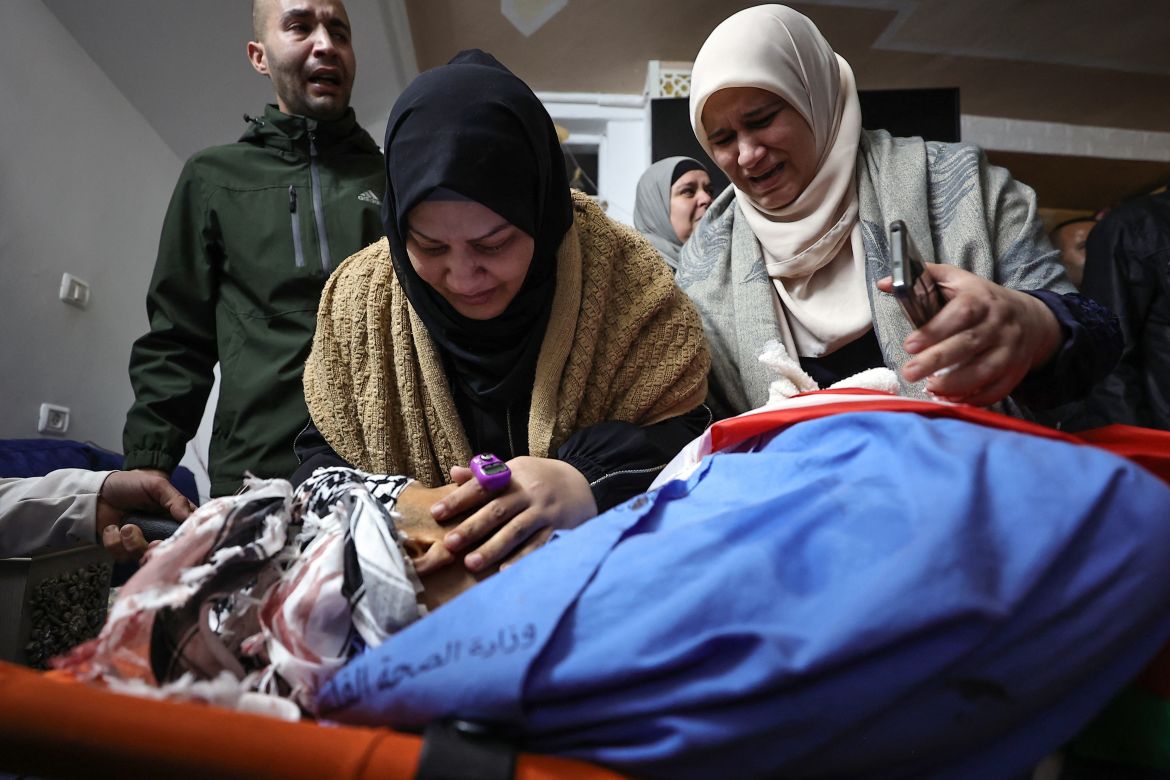 Palestinians mourn over the body of a relative during the funeral for six Palestinians killed in clashes with Israeli forces in the northern occupied West Bank city of Tulkarem on November 22.