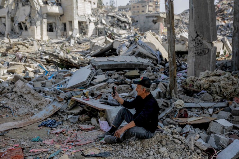 A Palestinian man uses his phone in Gaza