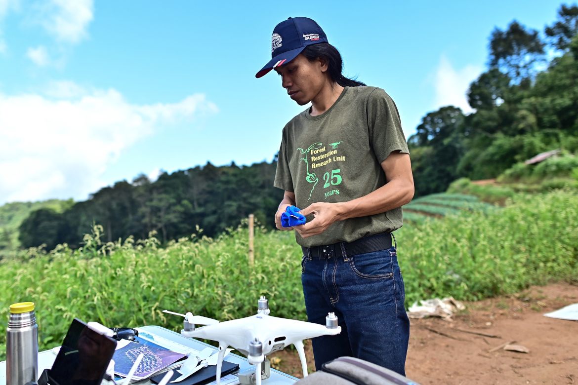 This picture taken on November 22, 2023 shows Chiang Mai University's Forest Restoration Research Unit (FORRU) field research officer Worayut Takaew packing his drone after a forest mapping session of a reforested area on a hillside near Chiang Mai.